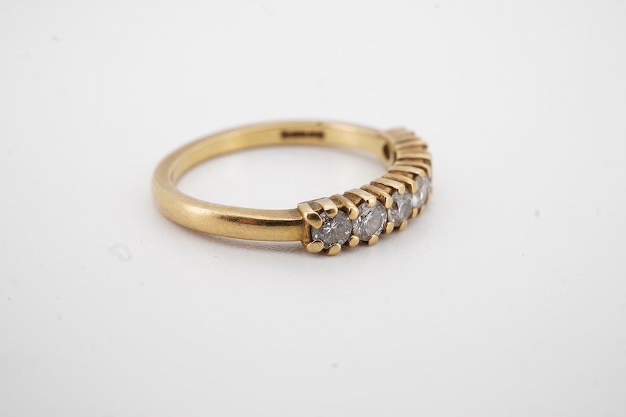 A modern 18ct gold and seven stone diamond set half hoop ring size O, gross weight 3.2 grams.